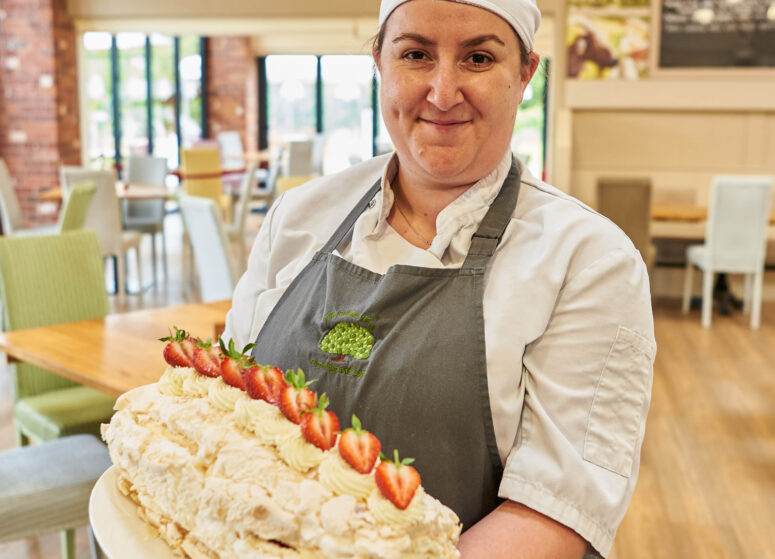 Team member Caroline, with a freshly prepared strawberry roulade