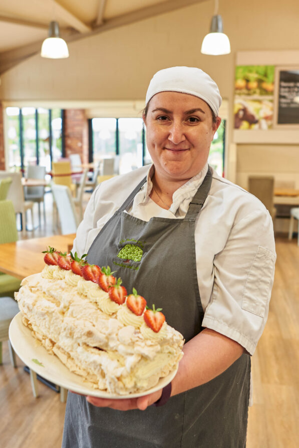 Baker holding a freshly made strawberry roulade